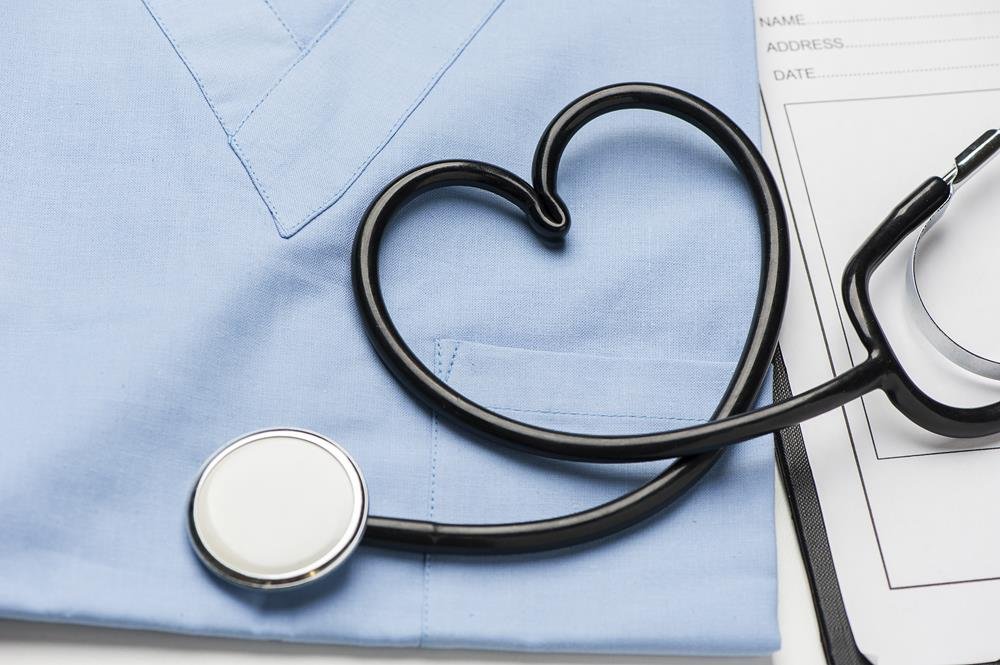 Fonendoscopio disposto a forma di cuore su un camice, check up dal cardiologo a Cagliari